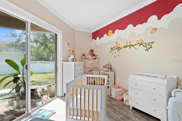 bedroom featuring hardwood / wood-style flooring, ornamental molding, and access to exterior