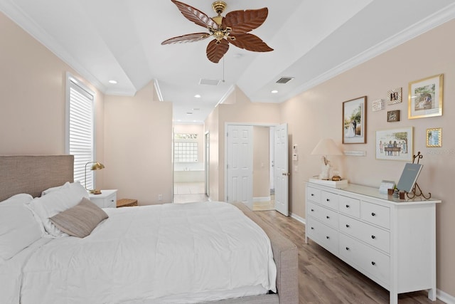 bedroom featuring crown molding, ensuite bath, ceiling fan, and light hardwood / wood-style flooring