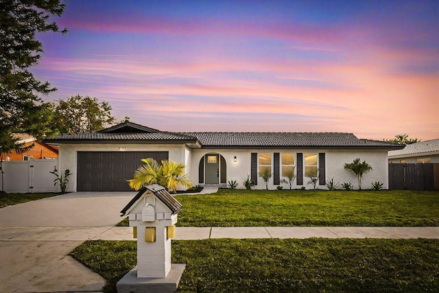 mediterranean / spanish house featuring a garage and a yard