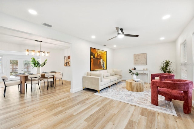 living room featuring french doors, ceiling fan, and light wood-type flooring