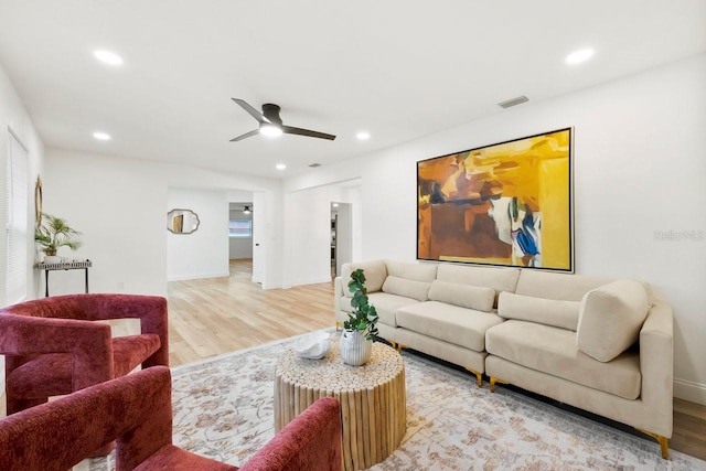 living room featuring ceiling fan and light hardwood / wood-style flooring