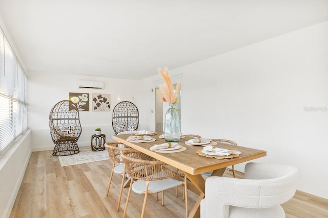 dining room with a wall mounted air conditioner and light wood-type flooring