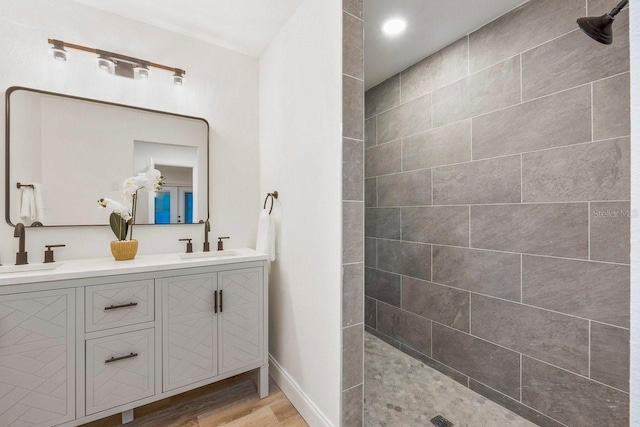 bathroom with vanity, wood-type flooring, and tiled shower