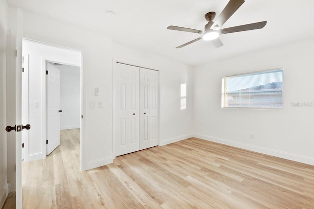 unfurnished bedroom with light hardwood / wood-style flooring, a closet, and ceiling fan