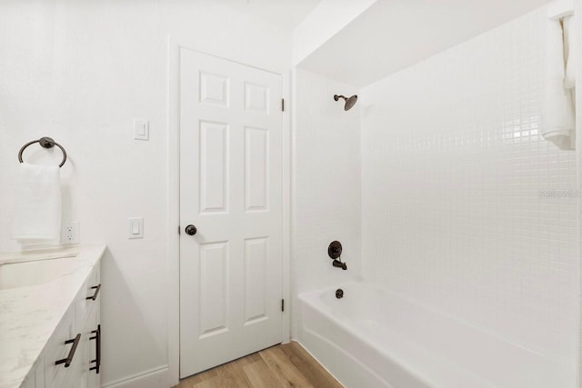 bathroom featuring tiled shower / bath combo, wood-type flooring, and vanity