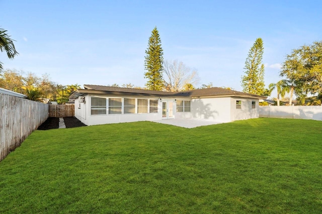 rear view of property with a yard and a patio area