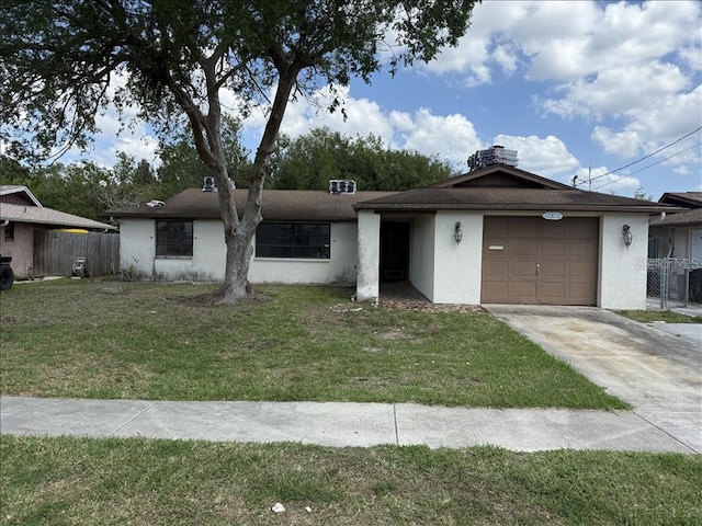 view of front of home with concrete driveway, stucco siding, fence, a front yard, and a garage