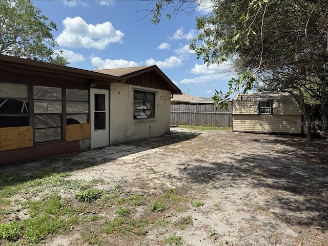 back of house with an outdoor structure and fence