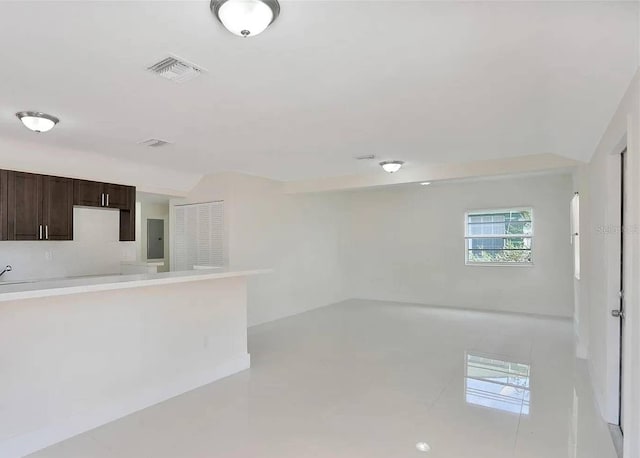 interior space with light tile patterned floors and electric panel