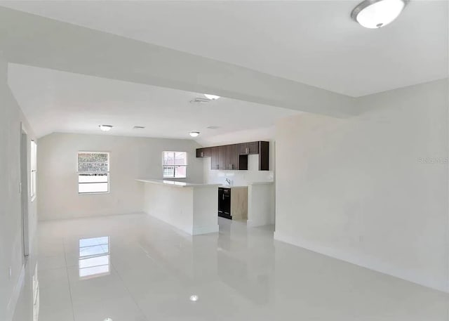 spare room with light tile patterned flooring, sink, and vaulted ceiling