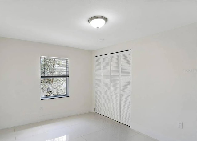 unfurnished bedroom featuring a closet and light tile patterned flooring