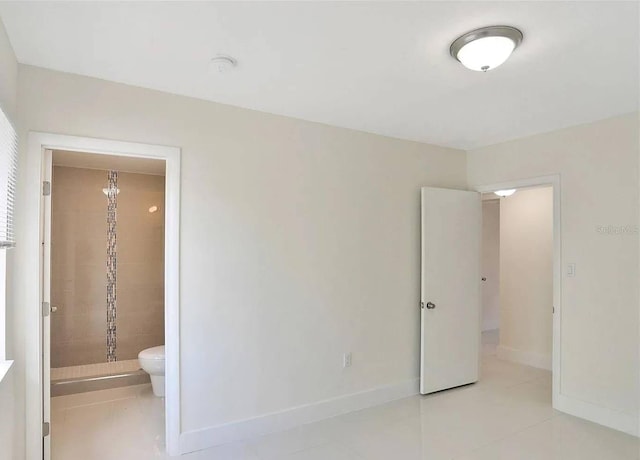 unfurnished bedroom featuring light tile patterned floors and ensuite bath