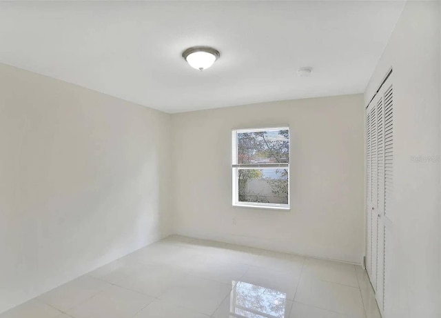 unfurnished bedroom featuring light tile patterned floors and a closet