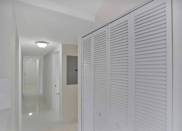 corridor featuring light tile patterned flooring and electric panel