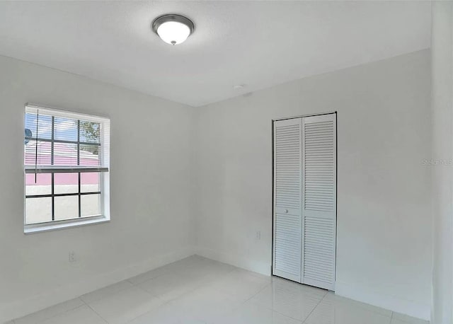 unfurnished bedroom featuring light tile patterned floors and a closet