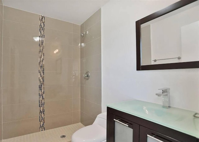 bathroom featuring tiled shower, vanity, and toilet