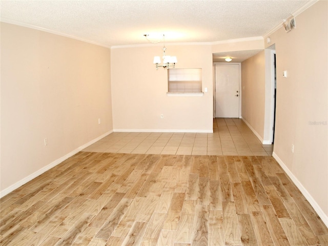 empty room featuring an inviting chandelier, crown molding, light hardwood / wood-style floors, and a textured ceiling