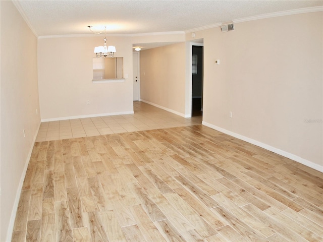 unfurnished room with an inviting chandelier, crown molding, a textured ceiling, and light hardwood / wood-style flooring