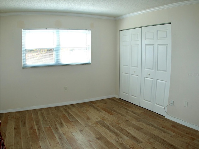 unfurnished bedroom featuring a closet, a textured ceiling, and light wood-type flooring