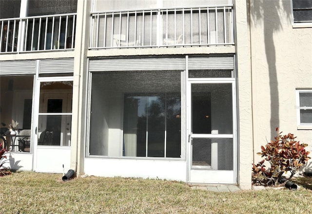 view of home's exterior with a yard and a sunroom