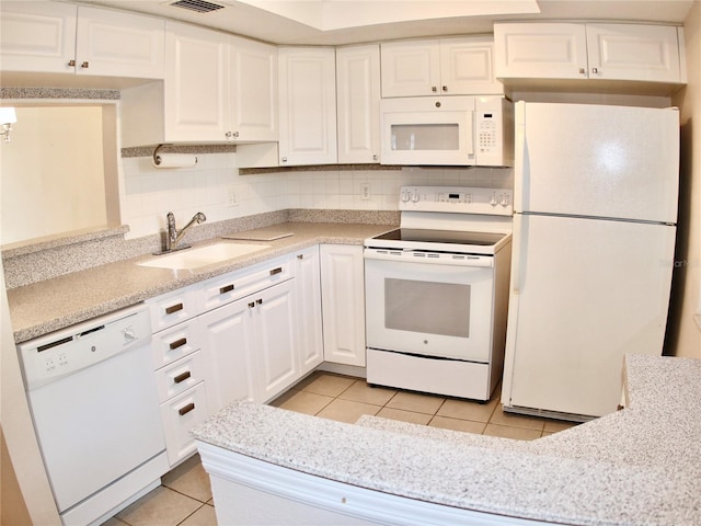 kitchen with sink, white cabinetry, tasteful backsplash, light tile patterned floors, and white appliances