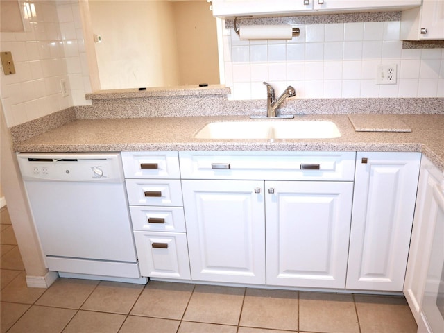 kitchen with sink, light tile patterned floors, dishwasher, white cabinetry, and tasteful backsplash