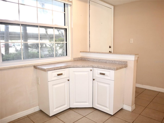 kitchen featuring light tile patterned floors and white cabinets