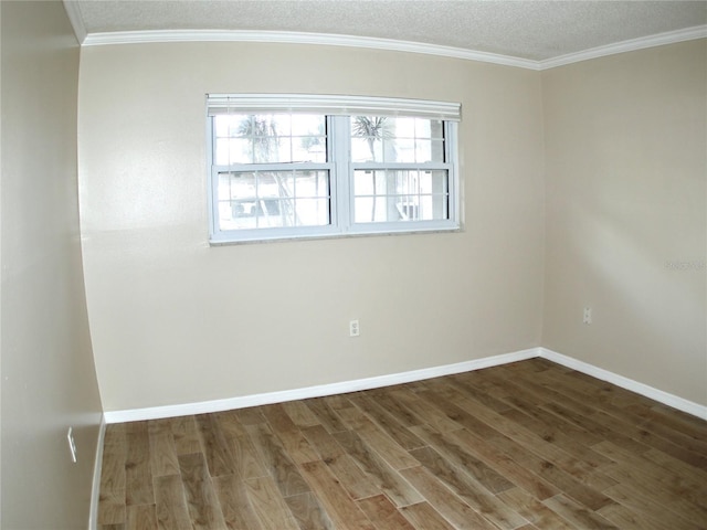 spare room featuring dark wood-type flooring, ornamental molding, and a textured ceiling