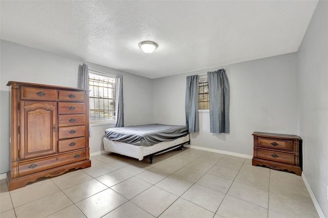 bedroom with a textured ceiling and light tile patterned floors