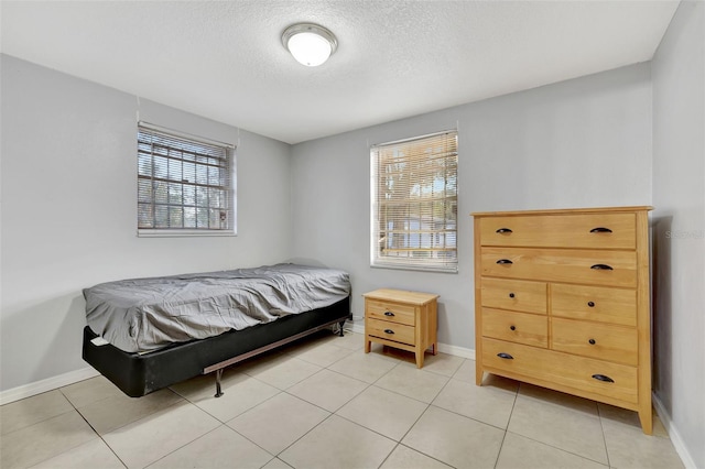 bedroom featuring a textured ceiling and light tile patterned floors