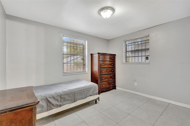 tiled bedroom featuring a textured ceiling