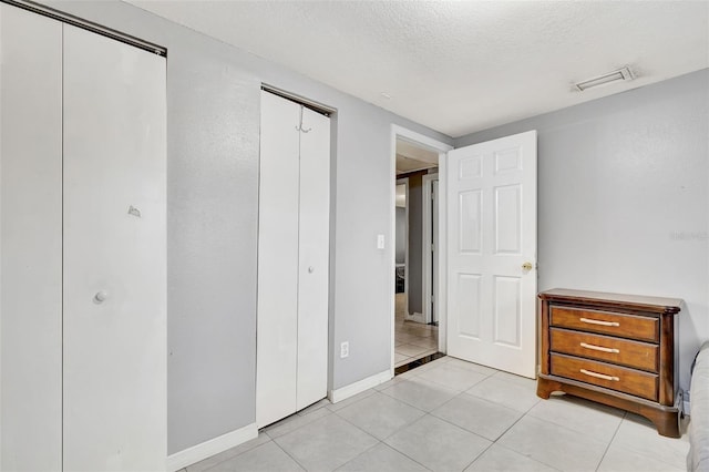 unfurnished bedroom with light tile patterned floors and a textured ceiling