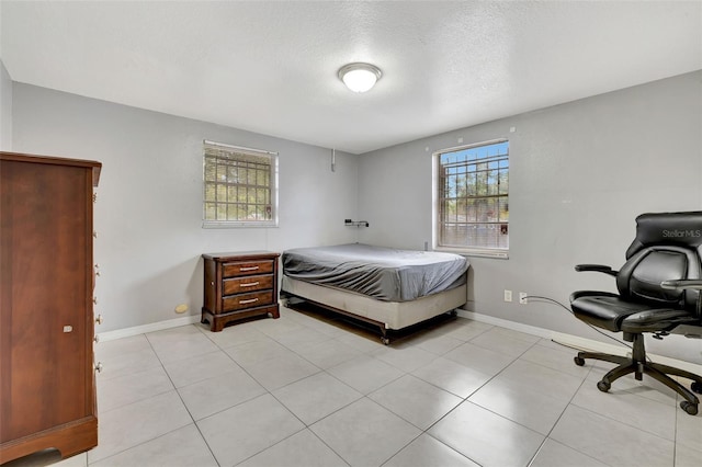 tiled bedroom featuring a textured ceiling