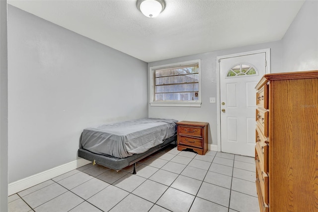 tiled bedroom featuring a textured ceiling