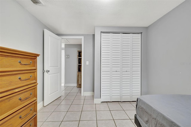 tiled bedroom featuring a closet and a textured ceiling