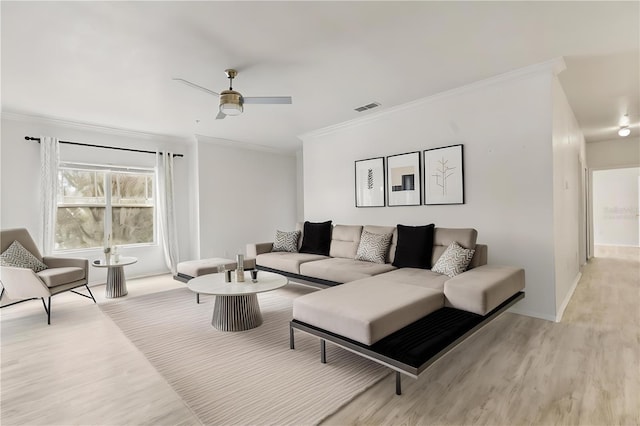 living room featuring ceiling fan, ornamental molding, and light hardwood / wood-style floors