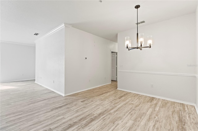 empty room with crown molding, light hardwood / wood-style floors, and a chandelier