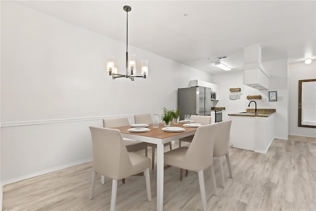 dining area featuring sink and light wood-type flooring