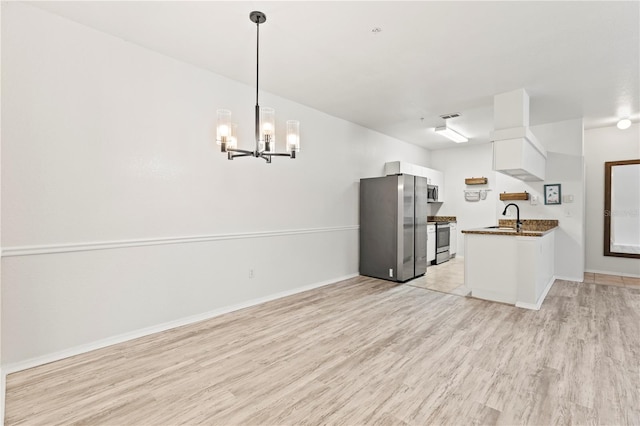 kitchen with sink, stainless steel appliances, light hardwood / wood-style floors, white cabinets, and decorative light fixtures