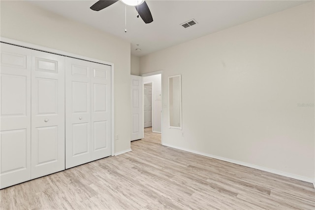 unfurnished bedroom featuring ceiling fan, light wood-type flooring, and a closet