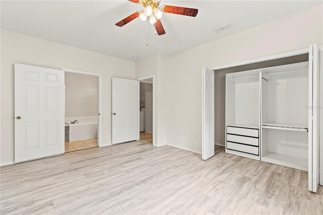 unfurnished bedroom with connected bathroom, washer / dryer, ceiling fan, light wood-type flooring, and a closet