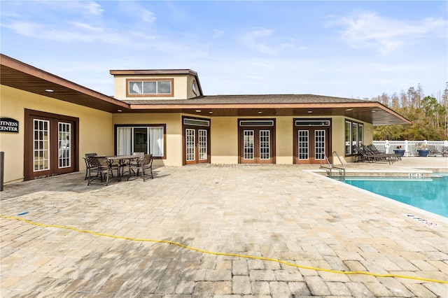 back of house featuring a community pool, a patio area, and french doors