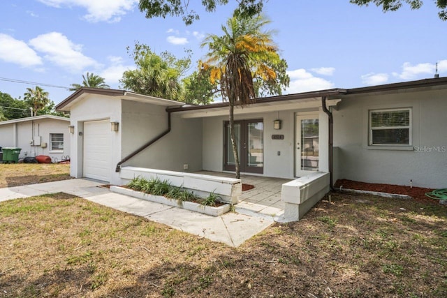 ranch-style home featuring a garage, a front lawn, and a porch