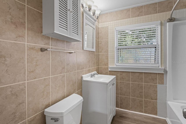 full bathroom featuring vanity, shower / tub combination, tile walls, and toilet