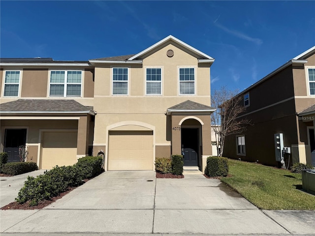 view of property with a garage and a front lawn