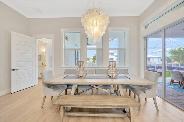 dining space with crown molding, a notable chandelier, and light hardwood / wood-style floors