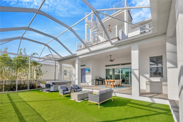 exterior space with a patio area, a balcony, a hot tub, a lawn, and ceiling fan