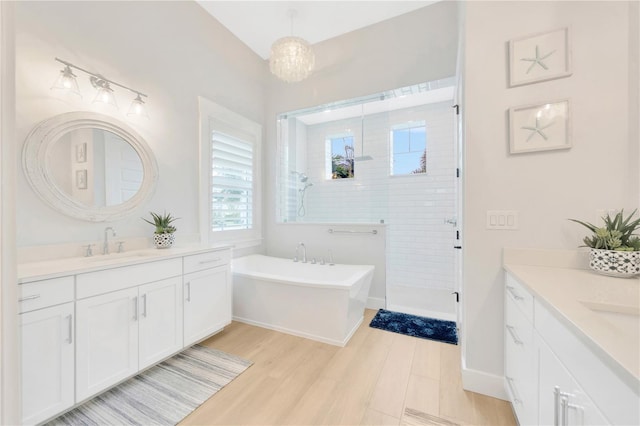 bathroom featuring shower with separate bathtub, wood-type flooring, and vanity