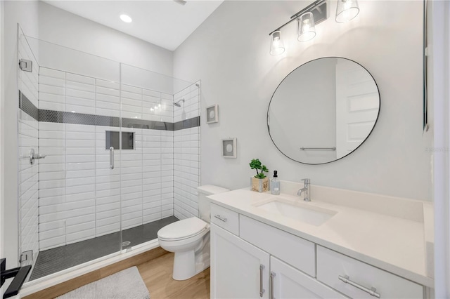 bathroom with vanity, hardwood / wood-style floors, toilet, and an enclosed shower