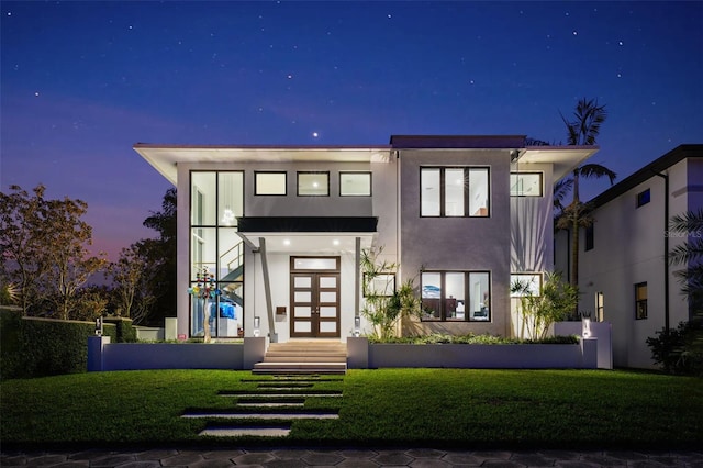 view of front of home featuring french doors, a yard, and stucco siding